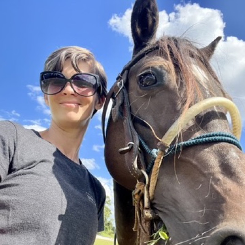 April with her horse under a blue Florida sky