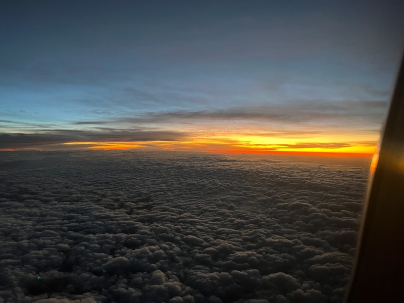 Sunset above the clouds from a plane window